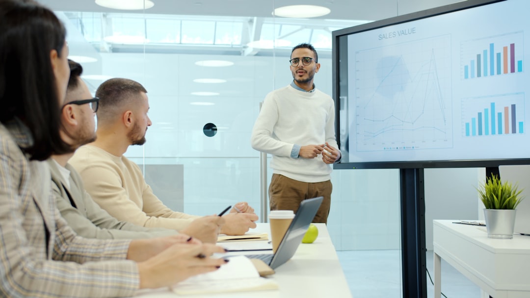 Man presenting charts to colleagues in a meeting. - Photo by Vitaly Gariev on Unsplash