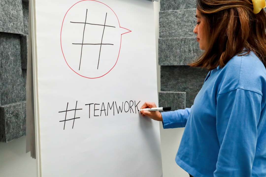 a woman writing on a white board with a marker - Photo by Walls.io on Unsplash