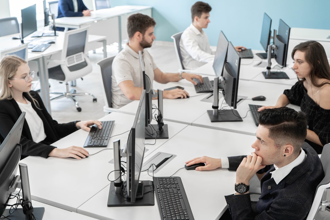 a group of people sitting at a table with computers - Photo by RUT MIIT on Unsplash