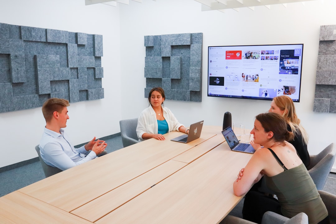 a group of people sitting around a conference table - Photo by Walls.io on Unsplash