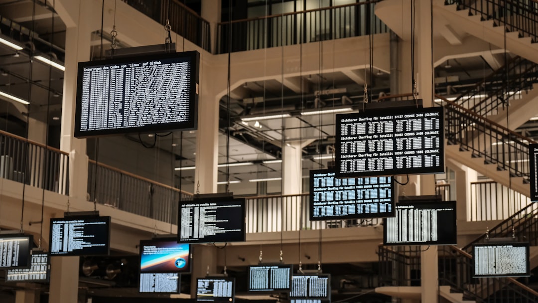 a bunch of television screens hanging from the ceiling - Photo by Leif Christoph Gottwald on Unsplash