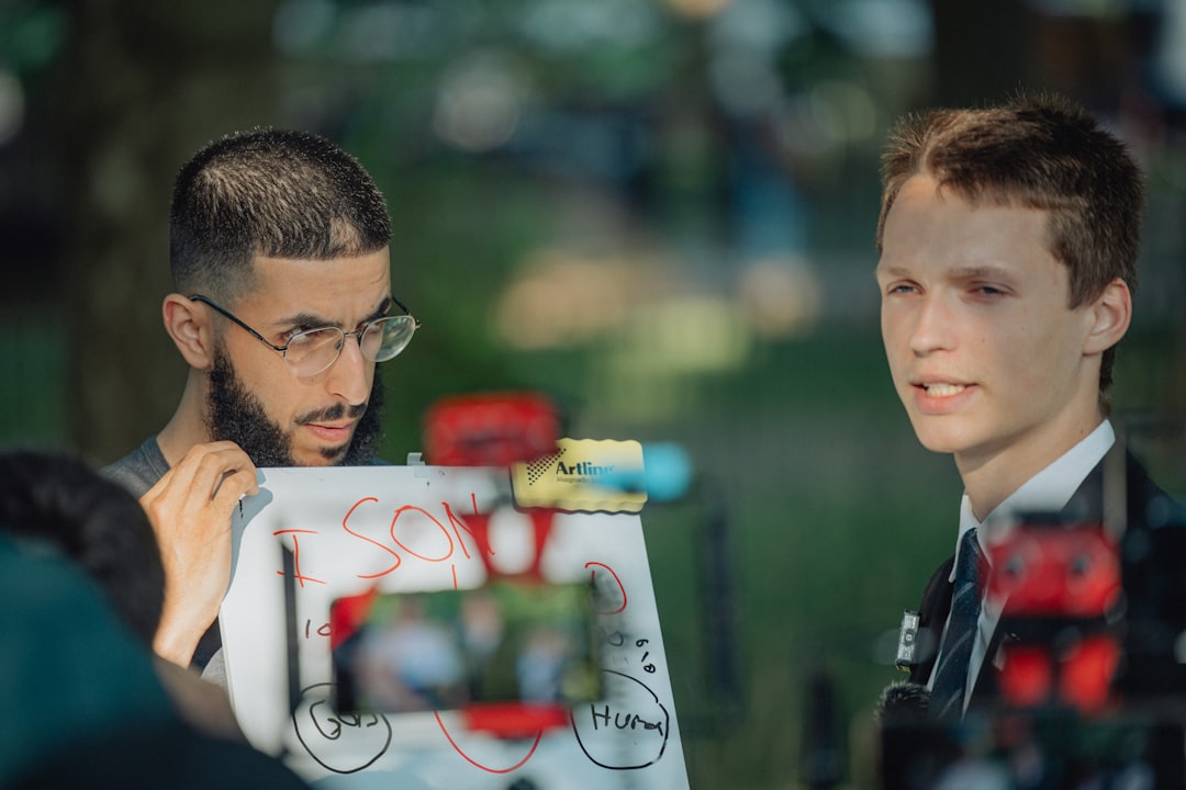 Two men filming a scene outdoors with artwork. - Photo by Luke Thornton on Unsplash